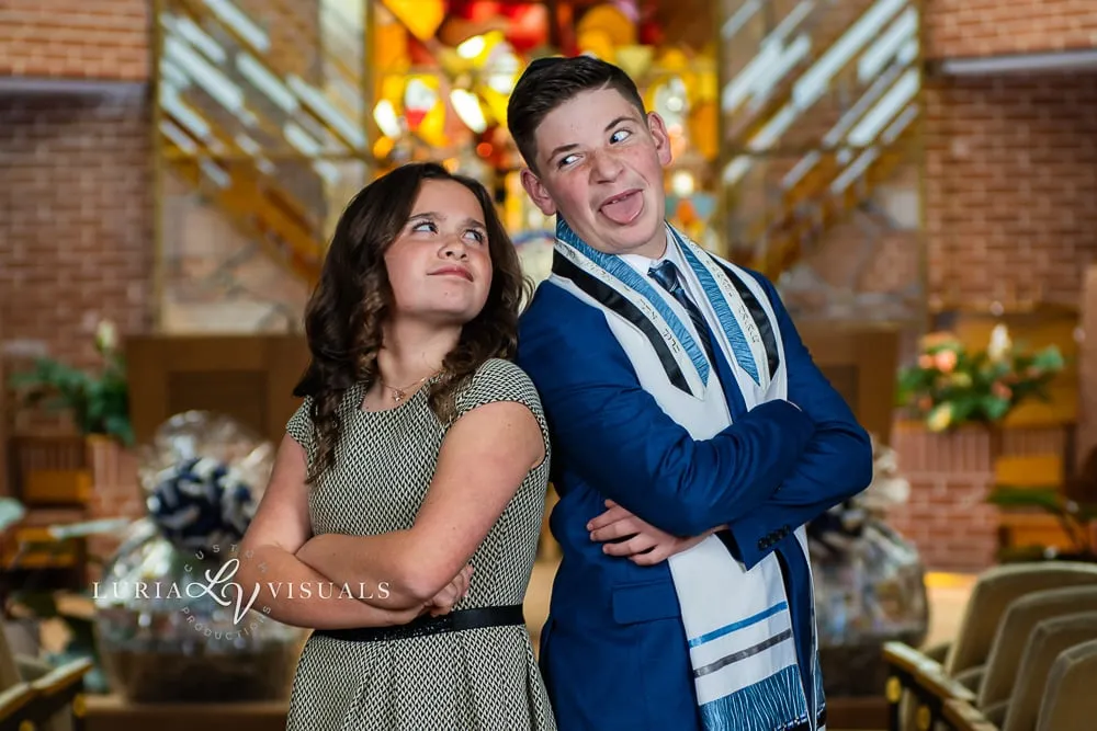Bar mitzvah boy and his sister in a playful portrait